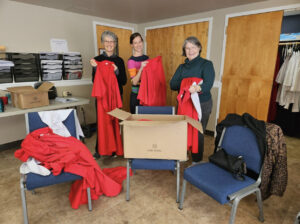 From left to right: Mary Alice Lodico, Rev. Joslyn Schaefer, and Music Director Ginny Moe pack up the donated choir robes.